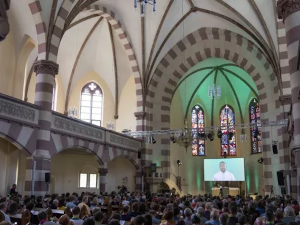 Аватар брадатог човека на екрану изнад олтара – вештачка интелигенција држи службу у цркви у Немачкој